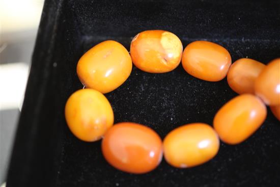 A single strand graduated ovoid amber bead necklace, 19in.
